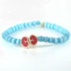 Pulsera artesanal de hueso de res tallado a mano con cristales celestes Santiago Rugeles.