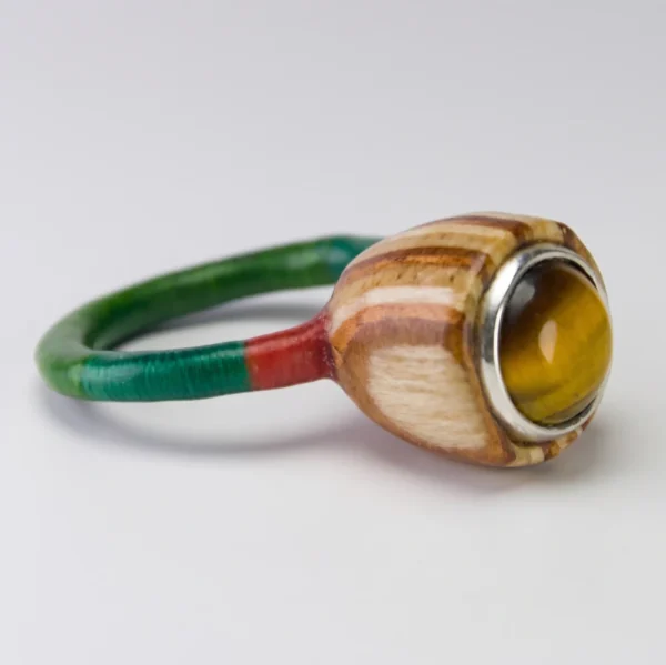 Anillo de autor Colección Semilla con ojo de tigre, engaste en plata 925, caja de madera de nogal, cedro y roble con aro verde.