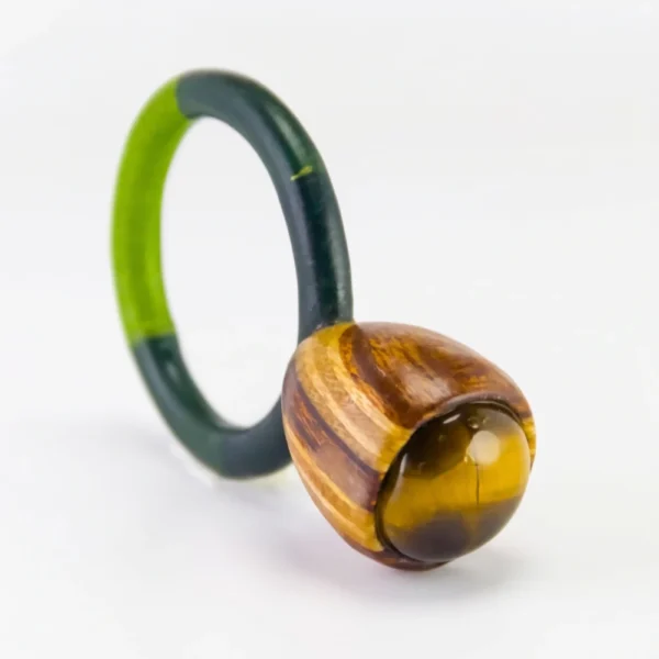 Anillo de autor de ojo de tigre engastado en caja bulbosa de madera de nogal y cedro con aro textil verde.