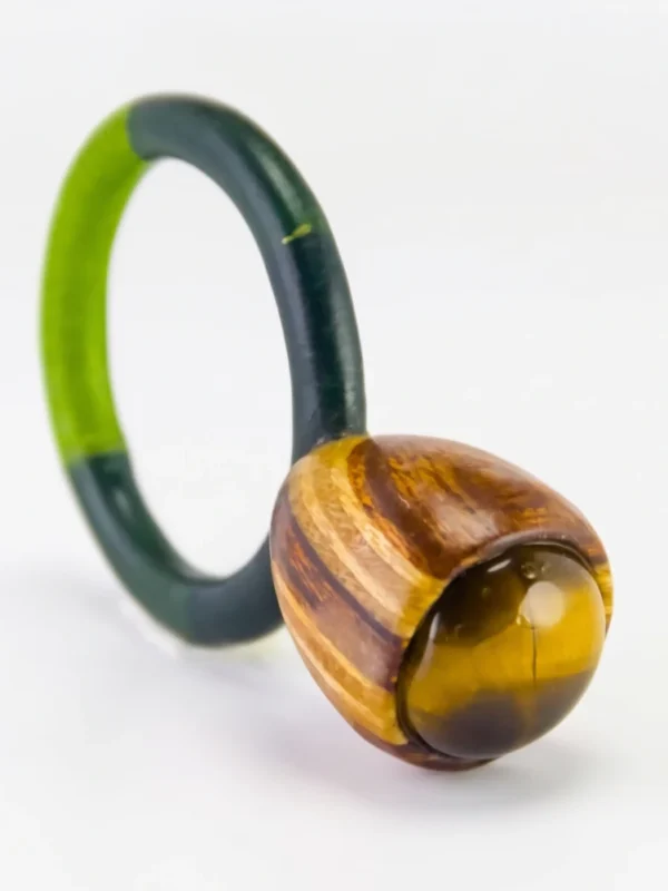 Anillo de autor de ojo de tigre engastado en caja bulbosa de madera de nogal y cedro con aro textil verde.